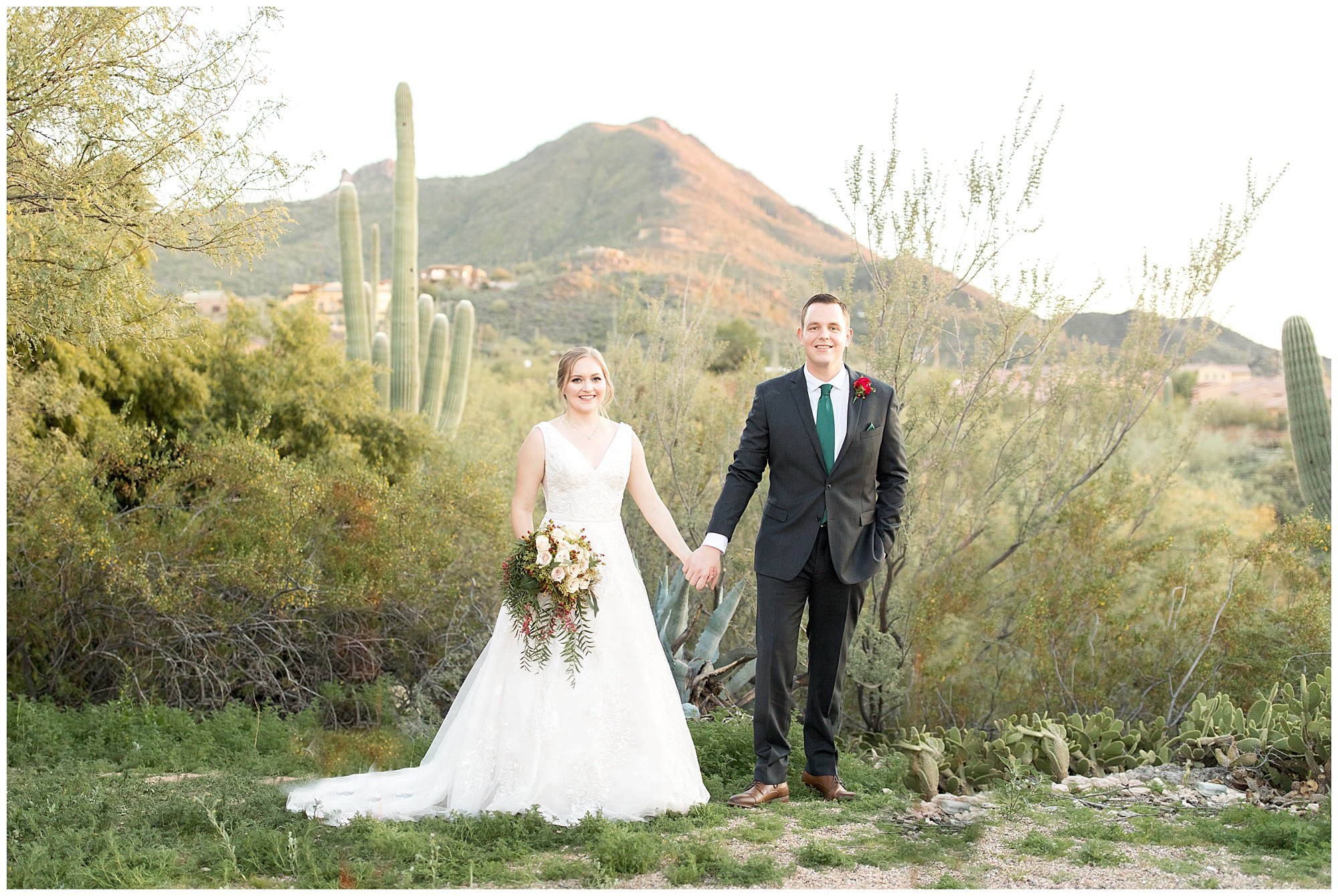 bride and groom at frontier town with cactus and mountain in the background at sunset
